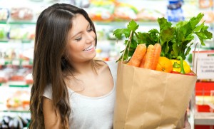 Woman holding a shopping bag full of vegetables