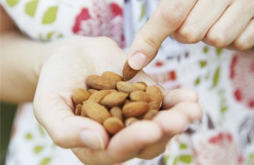 Woman eating handful of almonds